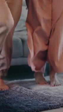 Samimi bir oturma odasında, yumuşak, pofuduk bir halının üzerinde dans eden kaygısız ve neşeli bir an.