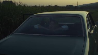 Sakin bir yakınlaşma, derin bir yansıma içinde bir kadın, bir arabada rahatça oturuyor, alacakaranlık yaklaşırken.