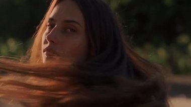 Zarif bir elbise giymiş bir kadın gün batımında canlı ve canlı tarlalarda zarifçe yürür.