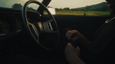 Aracın içinde, güzel manzaralı kırsal bir zemine karşı gergin ve dramatik bir an ortaya çıkıyor ve gerilim yaratıyor.