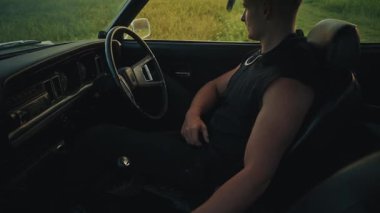 Aracın içinde, güzel manzaralı kırsal bir zemine karşı gergin ve dramatik bir an ortaya çıkıyor ve gerilim yaratıyor.