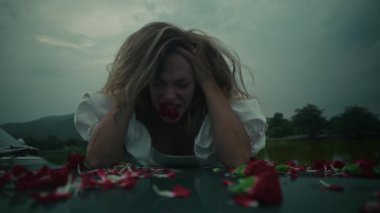 Dramatik bir manzarada, üzgün bir gelin, etrafa dağılmış gül yapraklarıyla çevrili iken derin duygularını gözler önüne serer.