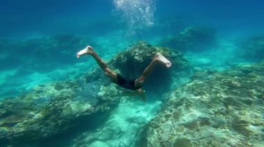 Mavi Deniz 'de Şnorkelle yüzen Adam. Su altında. Bir adamla Ocean Water 'da serbest dalış. Derin Deniz 'de şnorkelle yüzmek ve dalmak. Sığ suda deniz yaşamı. Yavaş Hareket 4k 'de Mercan Resifi yakınlarında Yüzen Kişi