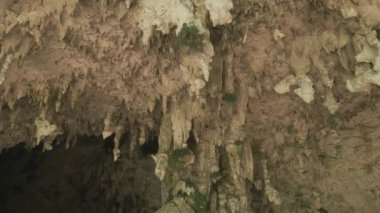 Arka planda Stalactites ve Stalagmitlerle Taş Mağara. Mineralleri ve karanlık mağarası olan doğa mağarası. Jeolojik ve Speleolojik Araştırma. Yeraltı Dünyası 'nın Keşfi 4k