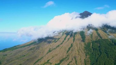 Yeşil Ormanlı Hava Manzaralı Doğa Dağı. Volkan Tepesi 'nin üzerinde Ormanlı Güzel Bulutlar. Tropikal Bölgedeki Görkemli Bulutlar. Drone Shot 'ta Parlak Güneşli bir gün. Destansı Top Gezegen Arazisi 4k