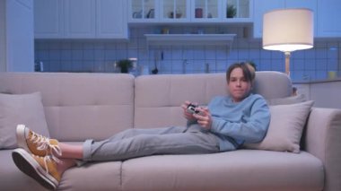 Koltukta oturan ve dijital konsolda video oyunlarında oynayan yakışıklı oyuncunun başarısı. Heyecanlı Oyuncu Adam Video Oyunu için Joystick 'i kontrol ediyor. Bir kişi oturma odasında oyun oynamaya odaklanmış.