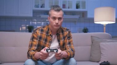 Bir Neşeli Adam 'ın Bilgisayar Oyunu Oynaması ve Modern Denetleyici Kullanması Hobisi. Gamepad Joystick 'te Eğlenmek İçin Ekrana Bakan Çekici Adam. Joypad 'de Erkek Kazanan Şans Zaferi Kutlaması