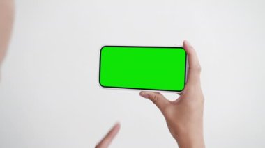 Genç Kadın Bak ve Yeşil Krom Anahtarlı Dokunmatik Ekran Telefonu Kullan. Cep Telefonu Modeliyle Kız Tıklama Hareketi. Kavram İzleme Programı İnternet Sosyal Medyasını, Aramaları, Haberleri Oku, Uygulamayı Çok Göster