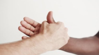 İki Etnik Erkek Arkadaş 'ın Yakın Çekim Güçlü Tokalaşması. İşbirliği ve Saygı Konsepti Dostluk İnsanları. Çok kültürlü ve uluslararası topluluk. Çokuluslu Milenyum Kolu Verme 4K