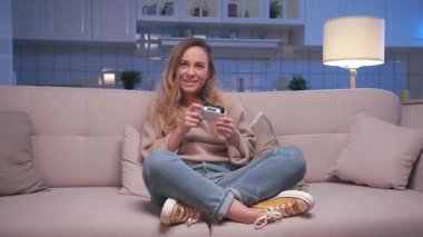 Bir Pretty Woman Video Oyunu Oynuyor ve Modern Kontrolcü Kullanıyor. Yetişkin Kız Ekrana Bakıyor ve Oyun Alanı Joystick 'iyle Eğleniyor. Evde Çekici Kadın Hobisinde Şans ve Zaferi Kaybediyor