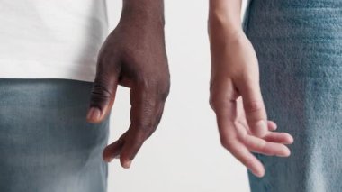 Genç kadın ve erkek el ele tutuşarak yakınlaşıyor. İki yetişkin insan kızı ve erkek parmaklarını birleştirir. Aşk Çifti 'nin Şehvetli Bağlantısı. Farklılık kavramı insanları. Şefkatli Mutluluk Hisleri