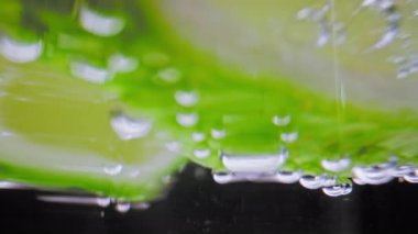 Köpüklü içecek ve limon dilimleri cam bardakta. Yakın plan. Macro 'daki Home on Studio Shot' da votka ya da beyaz rom kokteyli hazırlıyorum. Detoks sıvısı ya da Saf Mineral Aqua olarak Soda içmek