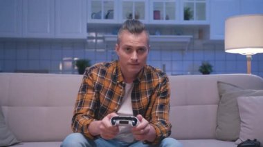 Bir Neşeli Adam 'ın Bilgisayar Oyunu Oynaması ve Modern Denetleyici Kullanması Hobisi. Gamepad Joystick 'te Eğlenmek İçin Ekrana Bakan Çekici Adam. Joypad 'de Erkek Kazanan Şanslı Zaferi Kutluyor