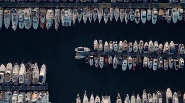 Sabah güneşinde Mavi Deniz Suyu 'ndan rıhtıma giden yatlar ve tekneler. Modern İnsanların Su Yolculuğu 'nda Havadan Bakış. Güneşli Sahilin Işıklarında Okyanus Turistleri için İş Su Sanatları