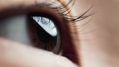 Yakından Çekilen Genç Asyalı Kadın 'ın Gözü. Güzel Iris 'in Macro görüntüsü ve Kirpikli Gözkapağı Altındaki Koyu Göz. Kornea ve Retina ya da Açık havada Soyut Kadın Kişisinin Temiz Temas Mercekleri