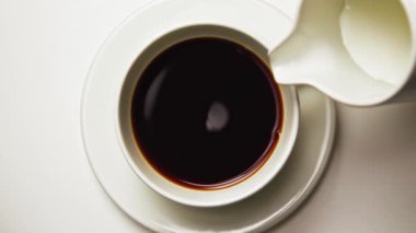 Beyaz Kupa 'da Kahve İçmek. Yakın plan. Espresso Cafe 'de Süt Kremalı Aromatik Arabika' nın Taze İçeceği. Makro 'daki Stüdyo Çekiminde Tasarım Kupasından Enerji İçme ve İçme Sıvısı