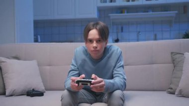 Kanepede oturan yakışıklı oyuncunun portresi ve Dijital Konsoldaki video oyunlarında oynamak. Heyecanlı Oyuncu Adam Video Oyunu için Joystick 'i kontrol ediyor. Bir Kişi Konferans Odasında Oyun Odaklandı