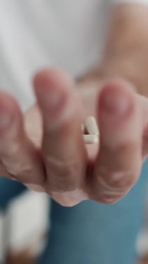 Adam hap alır ve gösterir vitamin ya da elinde ilaç tableti. Palm 'da el ele tutuşan beyaz hapların çeşitlerini kapatın. İlaç hapları, tanınmayan hasta elinin kapsülleri. Sağlık Konsepti 4k