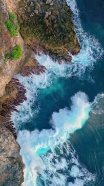 Sahildeki Dağ Kayalıkları 'nda Deniz Dalgaları Kırılıyor. Beyaz köpüklü Atlantik Okyanusu. Akdeniz 'deki Büyük Mavi Dalgalar. Fırtınalı Hava. Sinemada Uçan İnsansız Hava Aracı Suyun Üzerinde 4k