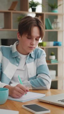 Ofisteki genç çocuk dizüstü bilgisayarda yazı yazıyor. Genç Öğrenci Masada Eğitici Not Defteri Ekranına Bakıyor. Akıllı Öğrenci İçin Sanal İletişim ya da Uzak E-Öğrenme Bilgileri