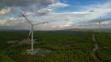 Aerial view of powerful Wind turbine farm for energy production on beautiful cloudy sky at highland. Wind power turbines generating clean renewable energy for sustainable development. 4k footage. High