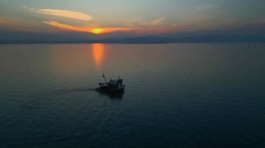 Balıkçı teknesi, gün batımından sonra denizde yüzüyor. Yüksek kalite 4k görüntü