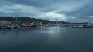 Urla, İzmir, Türkiye - Kasım 2022: Köy limanının manzarası. Limanda balıkçı tekneleri. Rıhtıma yakın bir sürü balıkçı teknesi var. Yüksek kalite 4k görüntü