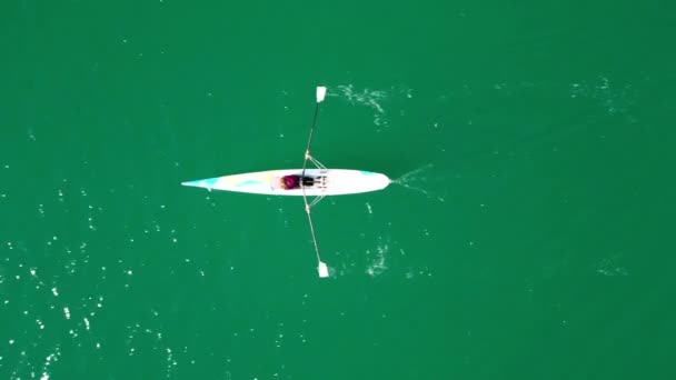 由年轻女子在翡翠清澈水域驾驶的空中无人驾驶飞机鸟瞰运动独木舟的视频 高质量的4K镜头 — 图库视频影像