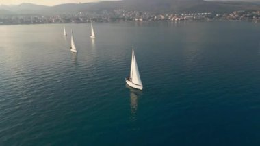 Yarış sırasında körfezdeki orta büyüklükteki yatların hava görüntüsü. Açık denizde yat gezintisi. 4K video görüntüleri. Yüksek kalite 4k görüntü