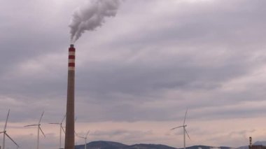 Güneş 'in aksine fabrika borusundan büyük, kırmızı ve beyaz bir boruyla sanayi bölgesi dökülüyor. Çevrenin kirliliği: dumanlı bir pipo. Kusursuz sinemagraf videosu