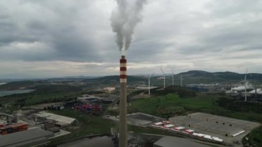 Güneş 'in aksine fabrika borusundan büyük, kırmızı ve beyaz bir boruyla sanayi bölgesi dökülüyor. Çevrenin kirliliği: dumanlı bir pipo. Kusursuz sinemagraf videosu