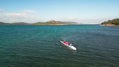 Dört kişilik bir ekiple birlikte sakin suda kürek çeken bir spor kanosu, Aerial view. Yüksek kalite 4k görüntü