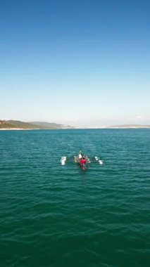 Sport Canoe with a team of four people rowing on tranquil water, Aerial view. High quality 4k footage