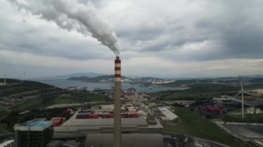 Güneş 'in aksine fabrika borusundan büyük, kırmızı ve beyaz bir boruyla sanayi bölgesi dökülüyor. Çevrenin kirliliği: dumanlı bir pipo. Kusursuz sinemagraf videosu