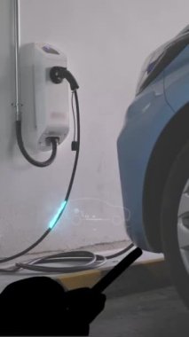 Mobil uygulama gösterici şarj durumu olan elektrikli araba için EV şarj istasyonu. Elektrik gücü, CO2 emisyonunu azaltmak için sürdürülebilir kaynaklardan şarj istasyonuna üretilir.