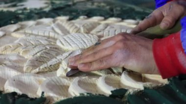 Erkek Ellerinin Kapanışı, ahşap mobilyalara oyma. Marangoz, Artistik Ahşap oymacılığı için alet kullanıyor. Ahşap bir panelde keski ve çekiçle ahşap bir süs üretiyor. Yüksek kalite 4k görüntü