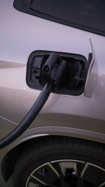 現代の技術と電気自動車のEv車への充電電力ケーブルポンププラグUi制御情報表示 車の給油所接続された電源ケーブル代替持続可能なエコエネルギー — ストック写真