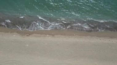 Havadan çekilen güzel yakın çekim sahili ve deniz suyu kum doğası ve seyahat konsepti videosu. Yüksek kalite 4k görüntü