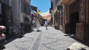 Urla, İzmir, Türkiye - 6 Mayıs 2024: İzmir, İzmir 'deki Urla sanat caddesinde hediyelik eşya dükkanları, kafeler ve insanlar. Yüksek kalite 4k görüntü