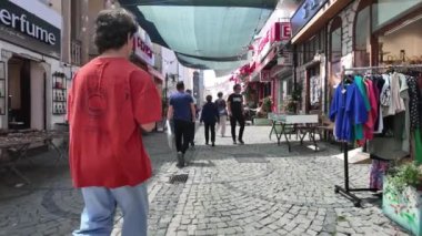 Urla, İzmir, Türkiye - 6 Mayıs 2024: İzmir, İzmir 'deki Urla sanat caddesinde hediyelik eşya dükkanları, kafeler ve insanlar. Yüksek kalite 4k görüntü