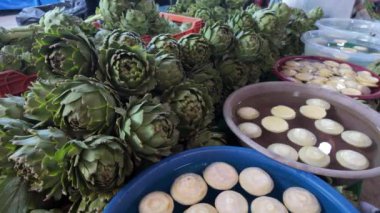  Urla Türkiye 'deki çiftçi pazarında taze enginarlı sebze standı videosu. Bölgesel mutfak, doğal sağlıklı gıda ve bolluk kavramı. Yüksek kalite 4k görüntü