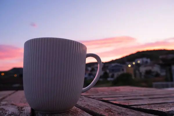 Während Die Sonne Untergeht Steht Eine Kaffeetasse Auf Einem Holztisch Stockbild
