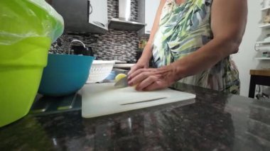 Parazit, öğle vakti küçük bir mutfakta şef bıçağıyla patates kesen bir kadının yakın çekimi. - Evet. Yüksek kalite 4k görüntü