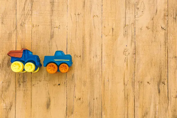 Side view of toy truck and van. Wooden aged yellow vintage surface