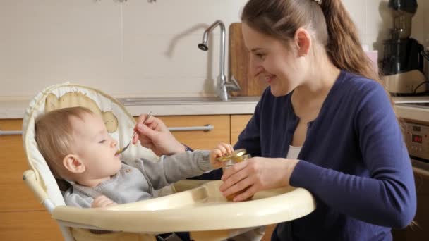 Portrait Smiling Young Mother Feeding Her Baby Son Fruit Porridge — Stockvideo