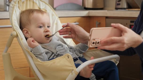 Portrait Little Baby Boy Watching Cartoons Smartphone While Eating Porridge — Vídeo de Stock