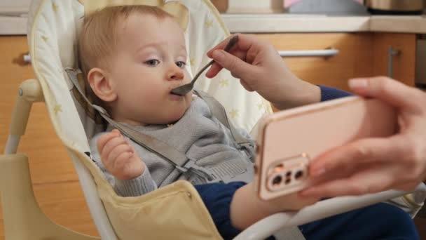 Moeder Tonen Video Smartphone Tijdens Het Voeden Van Haar Baby — Stockvideo