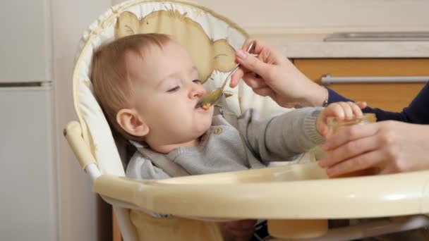 Closeup Little Baby Boy Getting Messy While Eating Porridge Highchair — Vídeos de Stock
