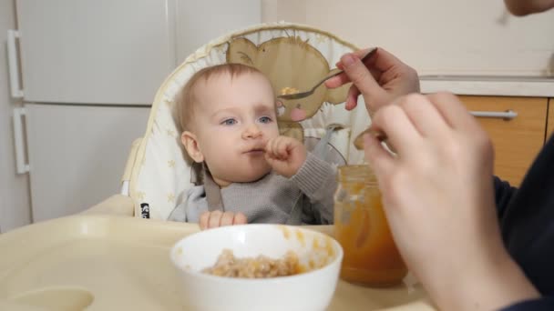 Portrait Little Baby Boy Getting Messy While Eating Porridge Highchair — Stockvideo