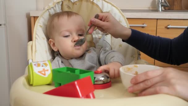 Portrait Little Baby Boy Playing Toys While Mother Feeding Him — Stockvideo